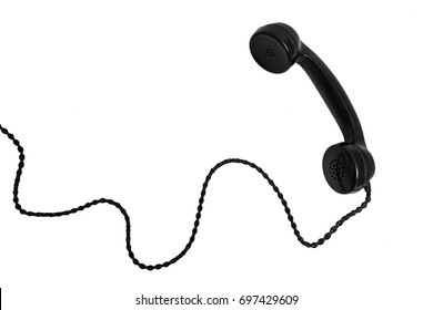 Old vintage stationary shiny black plastic telephone with a tube on the wire with a long cord on isolated background