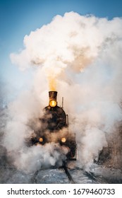 Old Vintage Steam Train On The Rail Road. Steam, Smoke Covering The Train. Retro Steam Train Departs From The Railway Station 