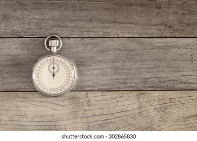 An Old And Vintage Stopwatch Over A Wooden Surface