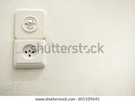 Old vintage switch and socket on a white plastered wall