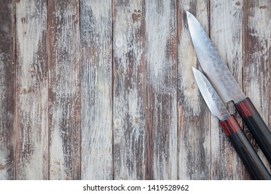 Old vintage table surface with pair of kitchen knives.