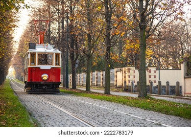 Old vintage tourist tram comes through the alley of a Prague city in an autumn day. Electric transport connection. Prague tram network is third largest in a world. Retro historic electro transport