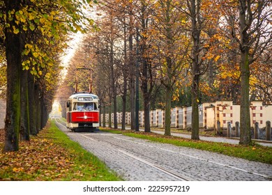 Old vintage tourist tram comes through the alley of a Prague city in an autumn day. Electric transport connection. Prague tram network is third largest in a world. Retro historic electro transport - Powered by Shutterstock