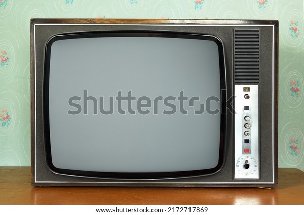 Old vintage TV in a room with vintage\
wallpaper. Interior in the style of the\
1960s.