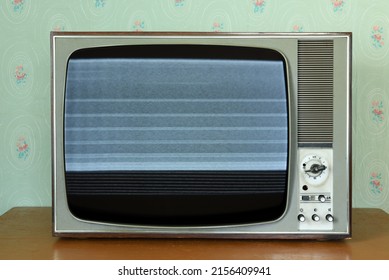 Old Vintage TV With Screen Noise In A Room With Vintage Wallpaper. Interior In The Style Of The 1960s.