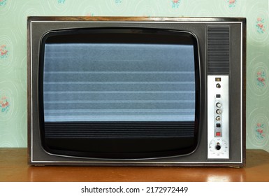 Old vintage TV with screen noise in a room with vintage wallpaper. Interior in the style of the 1960s. - Shutterstock ID 2172972449