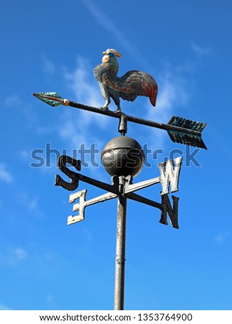 old vintage weathercock in iron on blue sky background