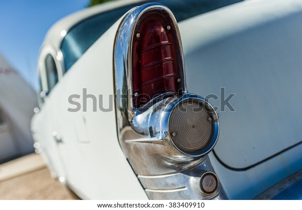 Old vintage white veteran car red rear tail light\
with blue sky