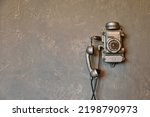 Old vintage wired telephone for communication on textured gray wall. Antique phone from past for design backgrounds. History of telephone in world. Concept of communications and telegraph. Copy space