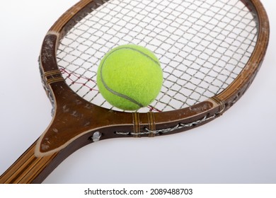 Old Vintage Wooden Tennis Racket And Yellow Ball Closeup