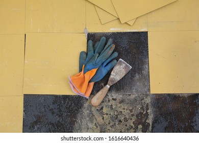 Old Vinyl Tiles Removing From Kitchen Floor, Spatula Trowel Tool And Gloves