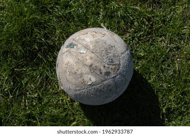 Old Volleyball Ball On Green Grass. Top View. Broken And Used Volleyball. Olympic Games