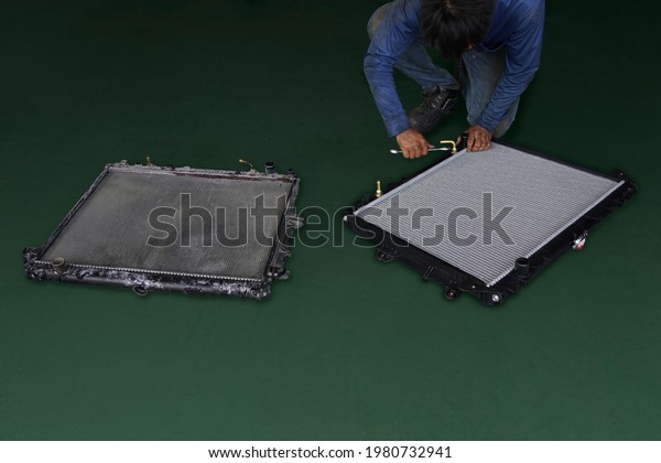 Old VS NEW Car\
aluminum radiator cooling panel unpacking new for car maintenance\
service isolated on green background. This has clipping path.      \
                            \
