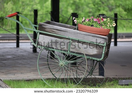 An old wagon cart that is filled with flowers outside of a train station in South Dakota.