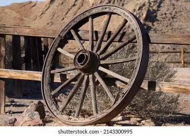 Old wagon wheel against a wooden fence