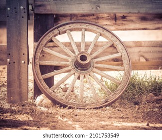 An old wagon wheel on fence