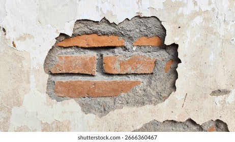 Old wall with cracks and a fall off piece of cement showing bricks. for Background, texture.