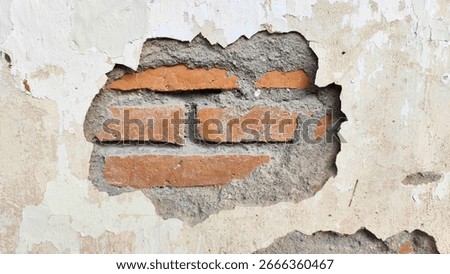 Old wall with cracks and a fall off piece of cement showing bricks. for Background, texture.