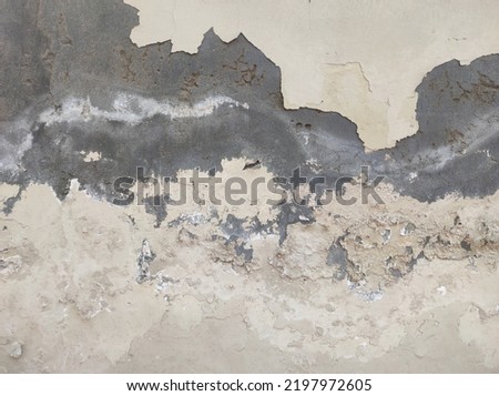 Old Wall damaged with blown Plaster and paint clog,peeling paint damage,water damage on building wall.Grunge abstract background.Wall fragment with scratches and cracks.Old distressed wall backdrop.
