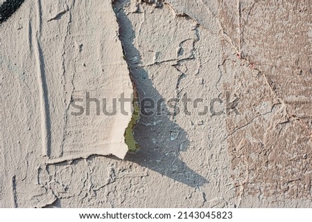 An old wall damaged- city building. Architecture- abstract background. Remnants of paint and plaster