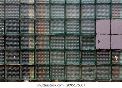 Old Wall Made Of Square Glass Tiles. Rough Ribbed Surface Of Dirty Green Glass Of Window. Vintage Texture For Background And Design.