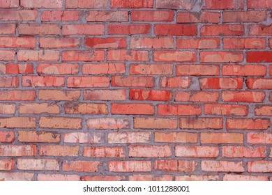 Old wall of red refractory brick, sometimes damaged
