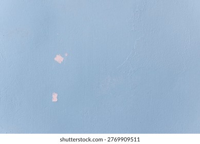 An old wall surface with peeling paint and deepening cracks