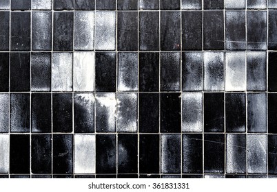 Old wall tiles with every shade of grey.