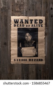 Old Wanted Poster Nailed To A Rough Wooden Wall With A Portrait Of The Criminal And A Promise Of Reward