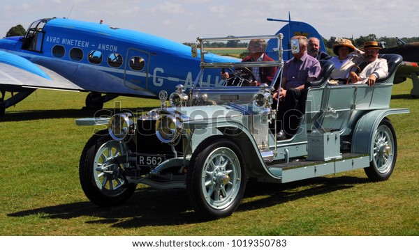 Old Warden Airfield,\
Beds / UK - 08/07/16:\
1908 Rolls-Royce Silver Ghost \'The Silver\
Dawn\' passing Avro 19 Anson at the Shuttleworth Collection\'s 2016\
Edwardian Pageant.