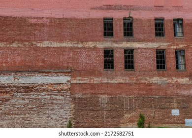 An Old Warehouse Exterior Wall Of Crumbling Brick And Windows Without Glass. 