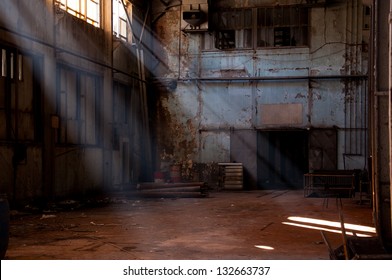 Old Warehouse, Sun Beams Coming From Broken Window To Inside Of An Old And Empty Abandoned Factory Building Or Warehouse With Dirty And Rusty Walls With Copy Space