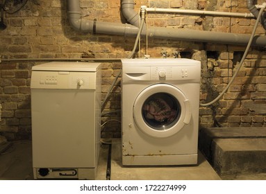 Old washing machines in the basement. Old washing machines on the background of sewer pipes - Shutterstock ID 1722274999