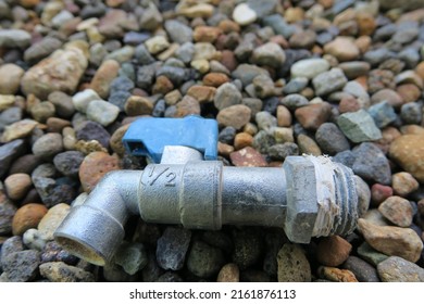 The Old Water Faucet Is Between Small Rocks