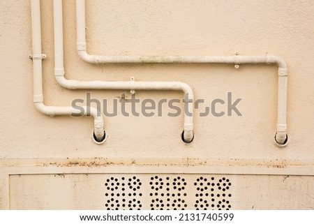 Old water and gas metal pipes fixed in front of a wall