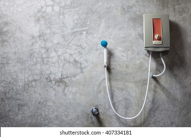 Old Water Heater On The Grey Cement Wall In Bathroom