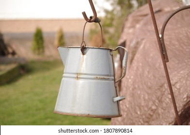 Old Watering Can Hanging From A Shepherds Hook