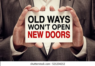 Old Ways Won't Open New Doors. Motivation quote. Success achievement concept written on a card in businessman hands