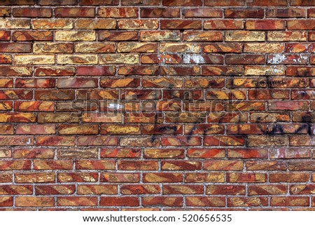 Old weathered brick wall of red brick with the remnants of the old paint has lost color. Creative brick background as a basis for the unusual design