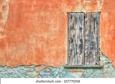Old weathered door by an orange wall