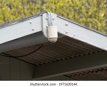 Old weathered motion detector for light attached to the front of the roof - Shutterstock ID 1971620144