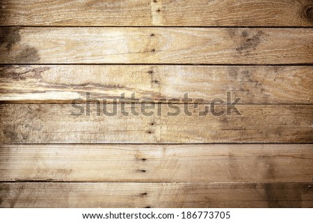 Old weathered rustic wooden background texture with vintage brown wood boards with an uneven row of nails in the centre and stained woodgrain pattern, empty with copyspace