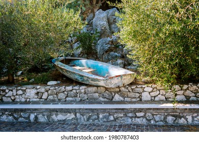 Old Weathered Turquoise Boat In The Unusual Location: Left In The Garden Between Two Olive Trees.