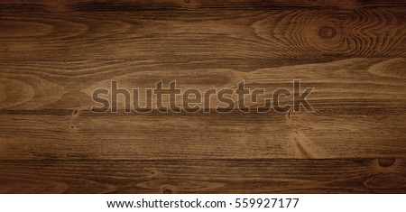 Old weathered wood surface with long boards lined up. Wooden planks on a wall or floor with grain and texture. Dark neutral tones with contrast.