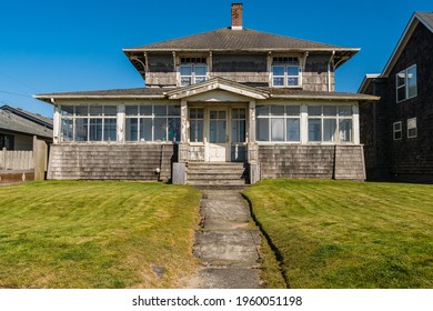 Old Weathered And Worn Coastal Beach Front House With Cedar Shake Shingles And White Windows.
