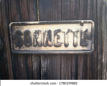 Old Weather-stained Sign Plate With The Embossed Inscription In French 