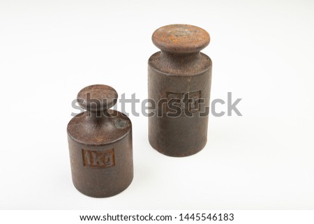 Old weights for weighing on a white table. Steel weights worth 1 and 2 kilograms. Light background.