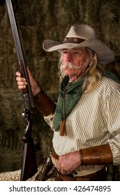 Old West Cowboy With Shotgun, Hat And Bandanna In Stable