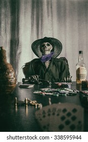 Old West Poker Skeleton Aces and Eights. Old west bandit outlaw skeleton at a poker table with a pistol and bourbon, cards showing aces and eights (dead man's hand) edited in vintage film style.