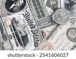 Old west US banknotes and silver certificates with silver dollar coins background